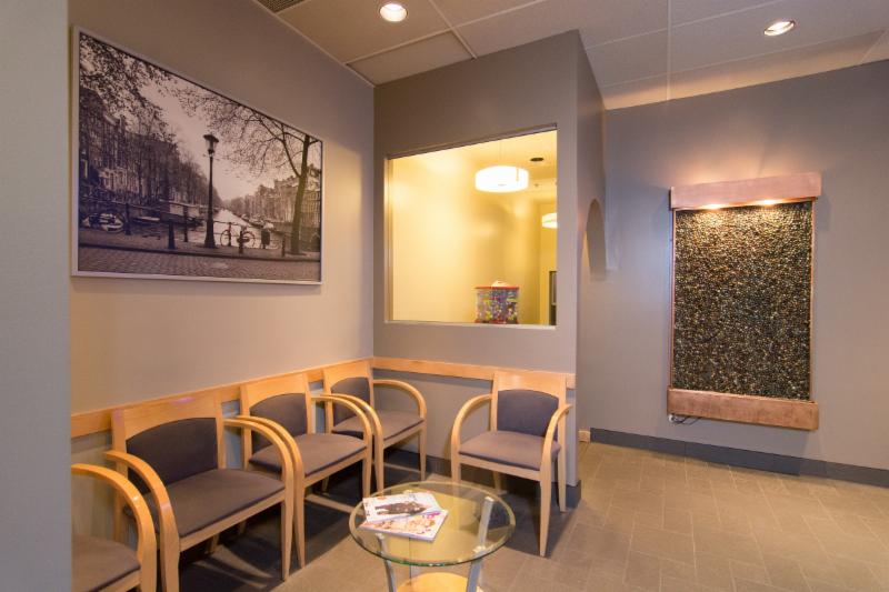 The waiting area at Surrey Place Dental Group, with chairs along the wall and a water feature